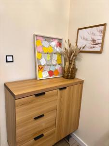 a wooden dresser with a picture on top of it at Apartament Majowa in Jelenia Góra