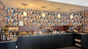 a restaurant kitchen with a counter with a gmaxwell gmaxwell at Kyriad Hotel Dijon Gare in Dijon