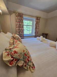 a bedroom with a large white bed with pillows at Grebe Cottage in Isle of Wight +11 photos