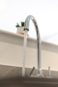 eine Küchenspüle mit Wasser aus einem Wasserhahn in der Unterkunft Bespoke Apartments Near Cardiff City Centre Free Parking in Cardiff