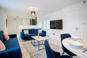 ein Wohnzimmer mit einem blauen Sofa und einem Tisch in der Unterkunft Bespoke Apartments Near Cardiff City Centre Free Parking in Cardiff