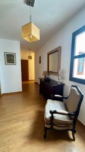 een kamer met een stoel, een dressoir en een spiegel bij Galteo Remedios in Ronda