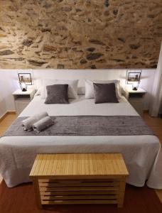 a bedroom with a large bed with a stone wall at La bóveda in Zafra