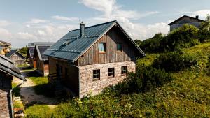 an old house with a metal roof on a hill at Chalets am Feuerkogel - LANDLUFT in Ebensee