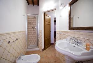 a bathroom with two sinks and a shower and a mirror at Casa vacanza vicolo degli orti in Monticiano +177 photos
