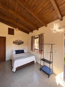 a bedroom with a bed and a wooden ceiling at Pousada Tudix in Praia do Rosa