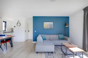 a living room with a couch and a blue wall at Groenlake Villa 6p Vakantie bungalow in Ewijk