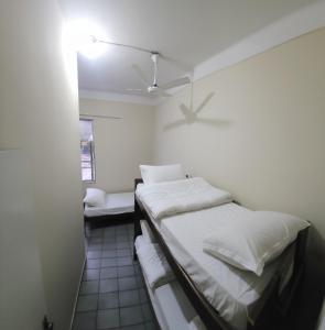 Cette chambre comprend deux lits et un ventilateur de plafond. dans l'établissement Estação Pousada e Hostel, à Cataguases