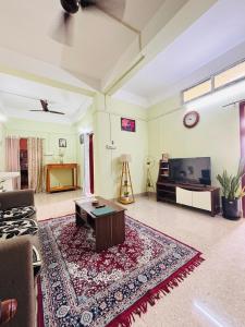 a living room with a couch and a tv at Aalohee Homestay in Guwahati