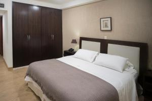 a bedroom with a large bed and wooden cabinets at Andares del Agua in Asuncion