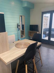 a dining room table with two chairs and a mirror at Jolie Maisonnette Studio in Saint-Herblain