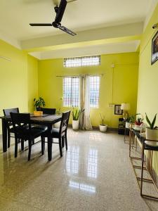 a dining room with yellow walls and a table and chairs at Aalohee Homestay in Guwahati