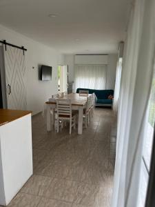 Una cocina y un comedor con mesa y sillas. en Cabaña del monte 1, en Monte Hermoso