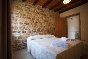 FulgatoreにあるBaglio Nuovo Country Villageの石壁のベッドルーム1室
