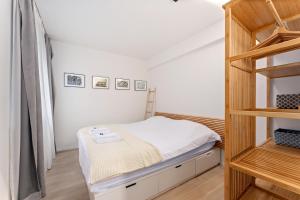 a small bedroom with a bunk bed and a ladder at Sparrenduin - Compact en cosy app aan golf De Haan in De Haan