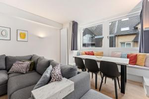 a living room with a couch and a table at Sparrenduin - Compact en cosy app aan golf De Haan in De Haan +3 photos