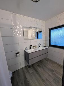 une salle de bain avec un lavabo et un miroir dans l'établissement Ferienwohnung Landkajüte, à Twist
