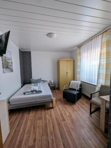 Cette chambre comprend un lit, un canapé et une chaise. dans l'établissement Ferienwohnung Landkajüte, à Twist