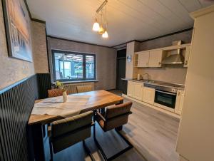 a kitchen with a wooden table and a dining room at Ferienwohnung Landkajüte in Twist +7 photos
