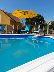 an empty swimming pool with an umbrella and chairs at Villa suzana in La Suze-sur-Sarthe