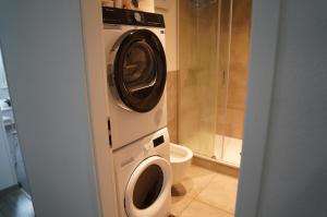 Una lavadora y secadora en un baño con inodoro. en Ihr Premium-Zuhause auf Zeit Komfortabel Wohnen in Bestlage, en Hannover 13 fotos más