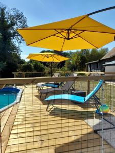 a patio with tables and umbrellas next to a pool at Villa suzana in La Suze-sur-Sarthe +51 photos
