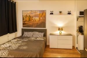a bedroom with a bed and a painting on the wall at CityNest Hannover O5 in Hannover