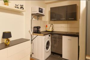 a kitchen with a washing machine and a microwave at CityNest Hannover O5 in Hannover