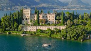 un bateau sur l'eau devant un grand bâtiment dans l'établissement Time to Relax - Lago di Garda - Adults only, à Ponti sul Mincio