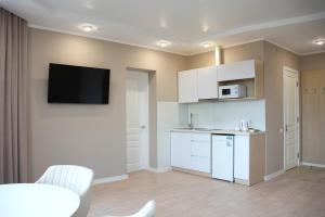 a kitchen with white cabinets and a tv on the wall at Elata Aparts in Skhidnitsa