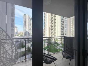 贝尔格莱德BW Arcadia RIVÉ Apartment的带椅子的阳台，可欣赏城市景观