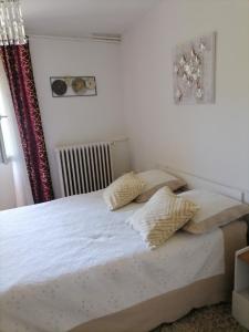 una camera da letto con un letto con due cuscini sopra di Appartement avec jardin et parking privés a Saint-Gaudens Altre 7 foto