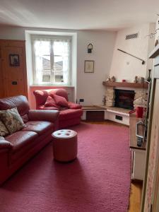 una sala de estar con un sofá y una chimenea en Casa Giò by Go New Location, en Terzolas