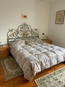 1 cama en un dormitorio con 2 alfombras en el suelo en Casa Giò by Go New Location, en Terzolas