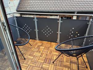 2 Stühle auf dem Balkon in der Unterkunft Ferienwohnung Aischgrund in Lonnerstadt