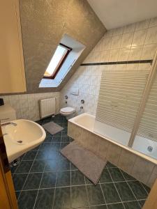 ein Badezimmer mit Waschbecken, Badewanne und Toilette in der Unterkunft Ferienwohnung Aischgrund in Lonnerstadt