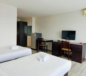 a hotel room with two beds and a desk and a television at Golden Good View Hotel, Chiang Mai in Chiang Mai +10 photos
