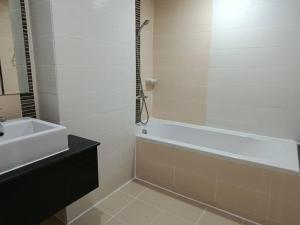 a bathroom with a bath tub and a sink at Golden Good View Hotel, Chiang Mai in Chiang Mai