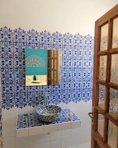 a blue and white bathroom with a sink and a mirror at Dar Naifer in Tozeur