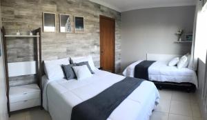 - une chambre avec 2 lits et un mur en bois dans l'établissement Lindo apartamento em condomínio com clube, à Cabo Frio