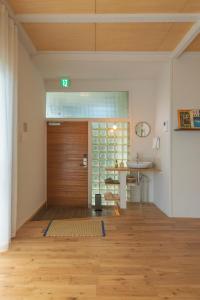 an empty room with a wooden door and a sink at YAMO-Izukogen in Yawatano