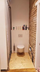 a bathroom with a toilet and a brick wall at 3-Zimmer Wohnung in Mannheim