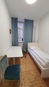a room with two beds and a table and a chair at 3-Zimmer Wohnung in Mannheim