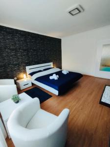 シャーロシュパタクにあるMoonlight Prémium Apartmanházのベッドとソファと椅子のある寝室