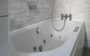 a white bath tub with a shower in a bathroom at Spacious city centre Flat in the heart of Chester in Chester