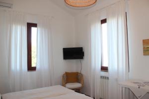 Un dormitorio con dos camas y un televisor en la pared. en Casale Il Girasole, en San Costanzo