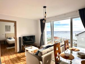 a living room with a couch and a view of the ocean at Apartamentos LAMAROSA -LAS PLAYAS in Burela de Cabo