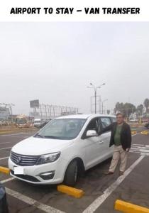 a man is standing next to a white car at Close to Airport - Free One Time Pickup - A y J Familia in Lima
