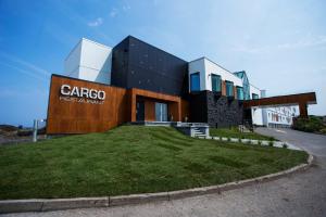 a building with a grass yard in front of it at Riotel Matane in Matane