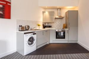 a kitchen with a washing machine and a washer at Modern City Centre Apartment in Bradford in Bradford